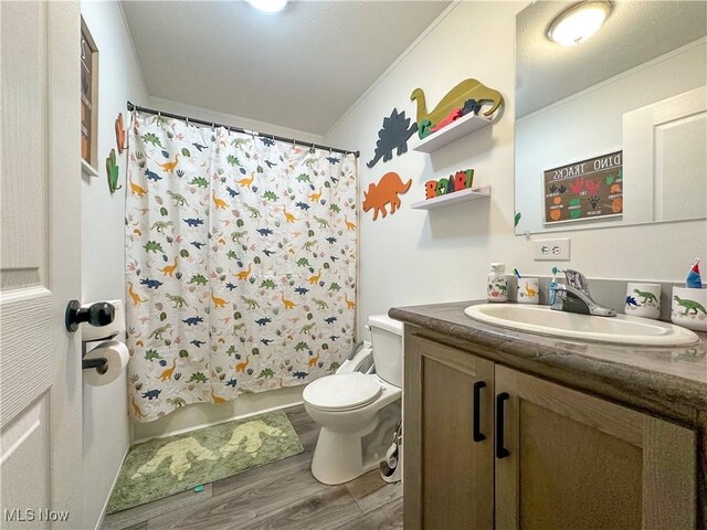 full bathroom with crown molding, shower / bath combination with curtain, toilet, vanity, and wood finished floors