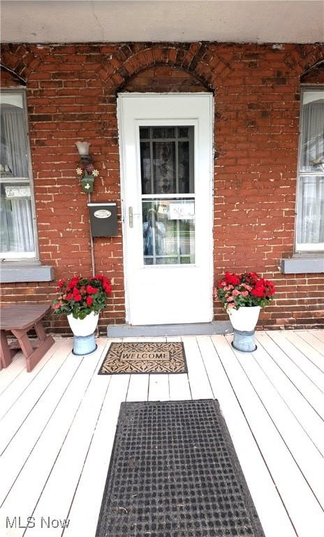 view of exterior entry featuring brick siding