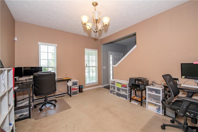 carpeted office with a wealth of natural light, a textured ceiling, and a chandelier