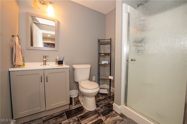 bathroom featuring tile patterned flooring, toilet, walk in shower, and vanity