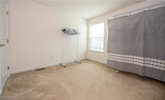 spare room featuring light colored carpet