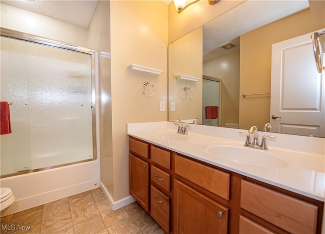 full bathroom with toilet, bath / shower combo with glass door, vanity, and tile patterned floors