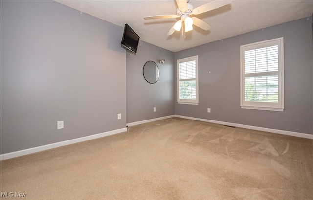 carpeted empty room featuring ceiling fan and a healthy amount of sunlight