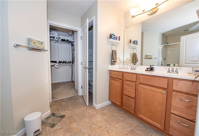 bathroom with toilet, tile patterned flooring, an enclosed shower, and vanity