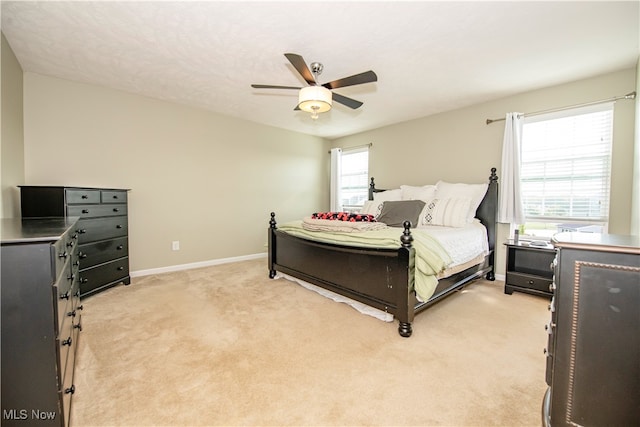 bedroom with ceiling fan and light carpet