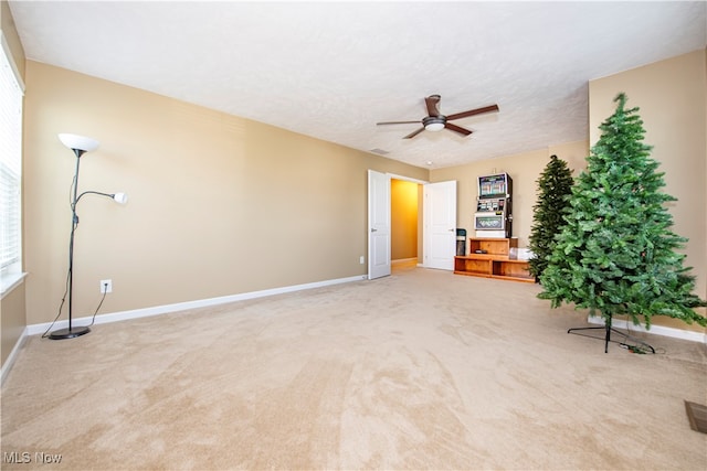 unfurnished living room featuring ceiling fan and light colored carpet