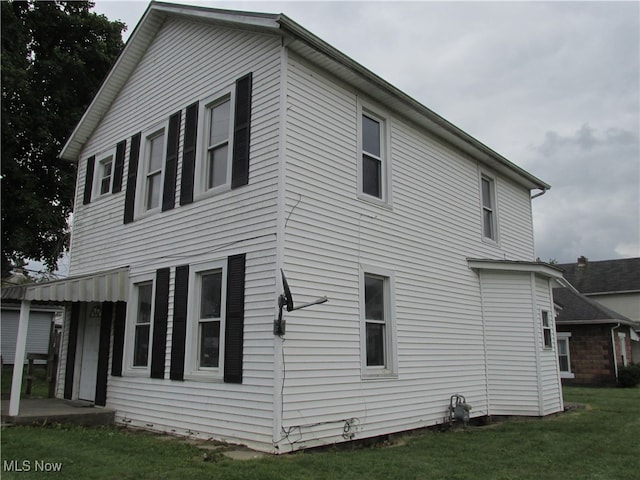 view of side of home with a yard