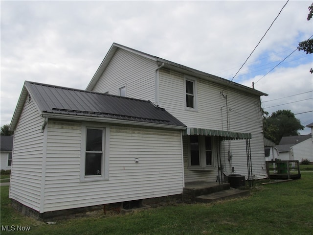 back of house featuring central AC and a yard