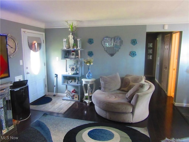 living area with baseboards and wood finished floors