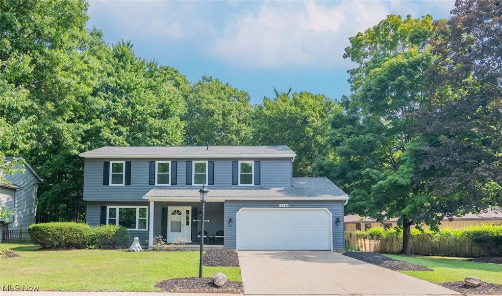 view of front of house with a garage, driveway, and a front lawn