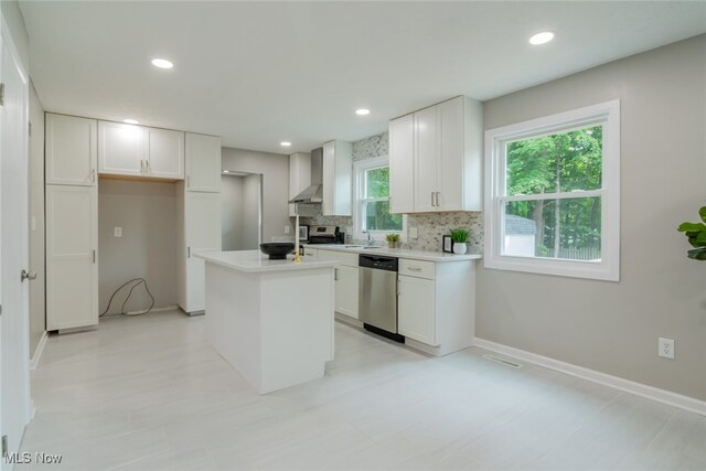 kitchen with backsplash, dishwasher, white cabinetry, wall chimney range hood, and a center island