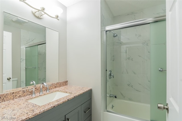 full bathroom featuring combined bath / shower with glass door, toilet, and vanity