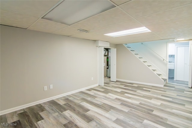 basement featuring light hardwood / wood-style flooring and a drop ceiling