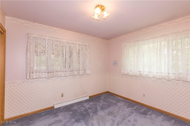 empty room with carpet flooring and a baseboard heating unit