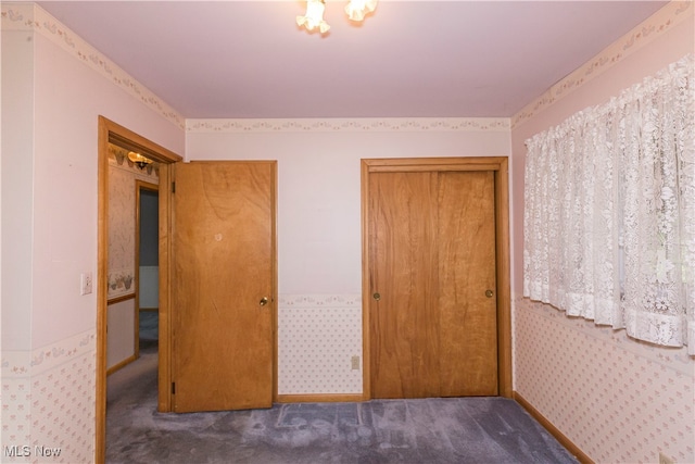 unfurnished bedroom featuring dark carpet