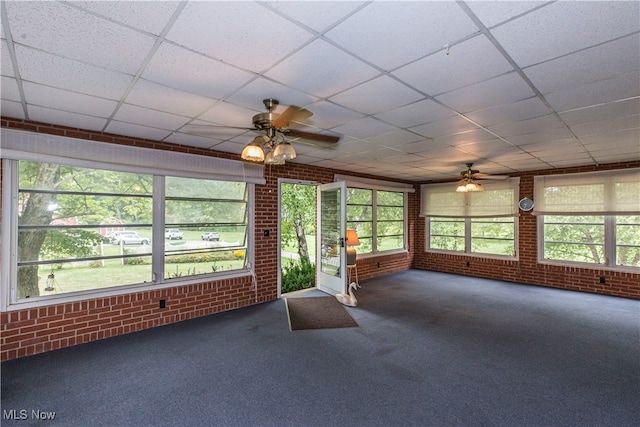 unfurnished sunroom featuring a wealth of natural light and a drop ceiling