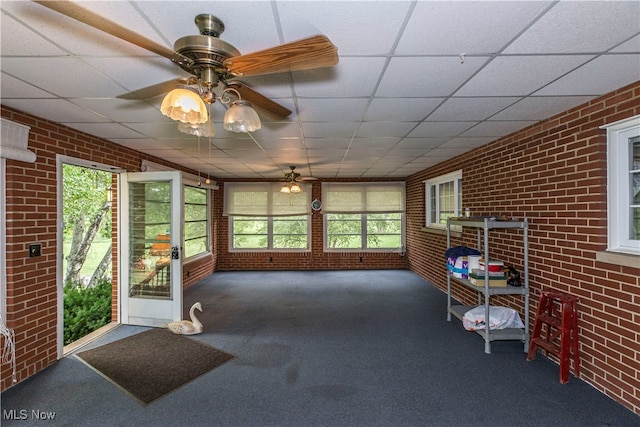 sunroom / solarium with ceiling fan and a drop ceiling