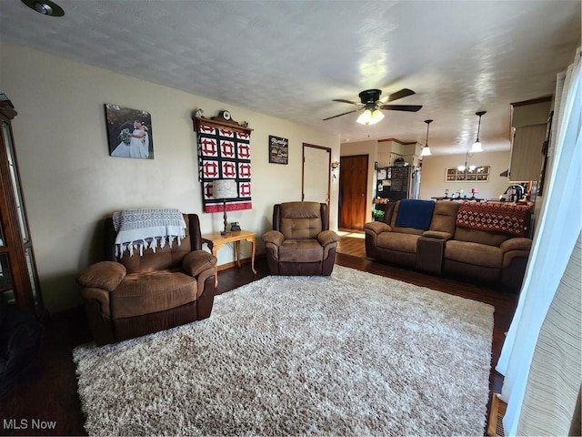 living room featuring dark wood-type flooring and ceiling fan