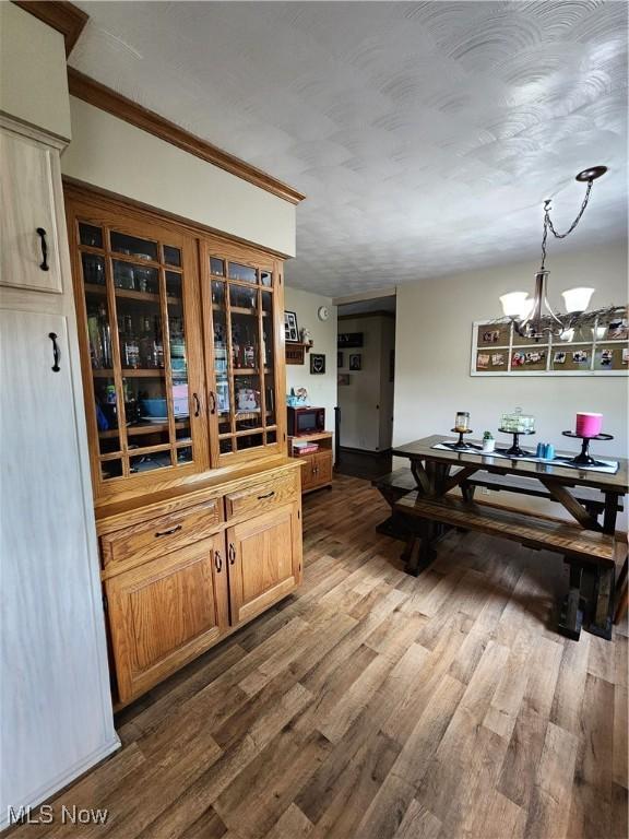 dining space with dark wood-type flooring and an inviting chandelier