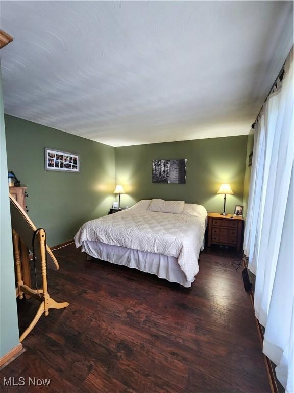 bedroom with dark hardwood / wood-style flooring