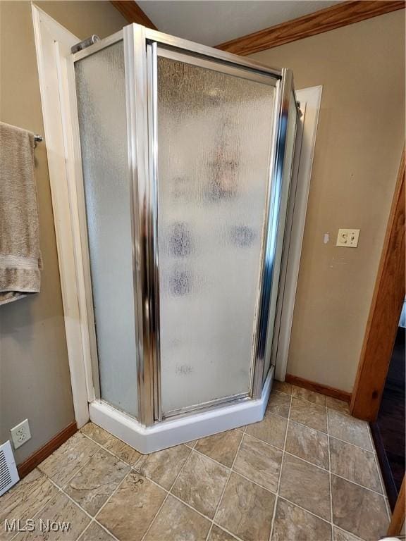 bathroom featuring ornamental molding and walk in shower