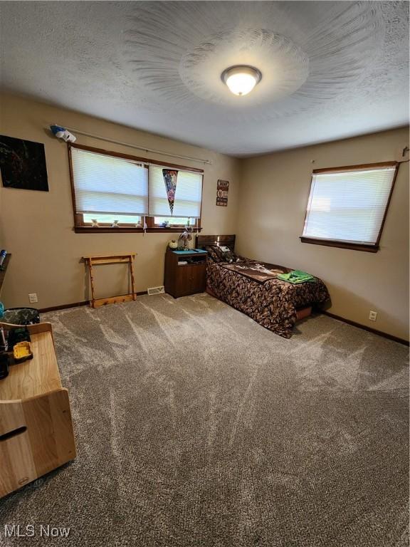 carpeted bedroom featuring a textured ceiling