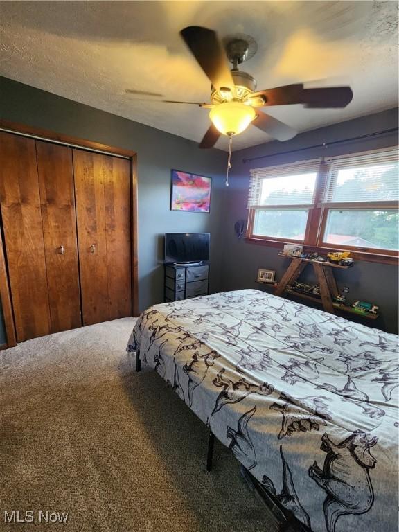 carpeted bedroom with a closet and ceiling fan