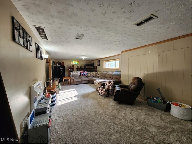 living room featuring wood walls, a textured ceiling, and carpet flooring