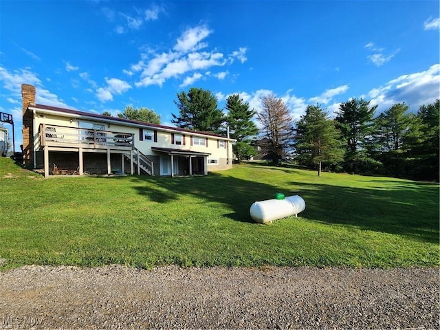 back of property with a deck and a lawn