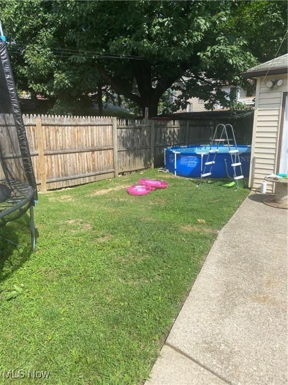 view of yard featuring fence and a fenced in pool