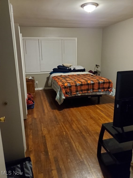 bedroom with dark wood-style flooring