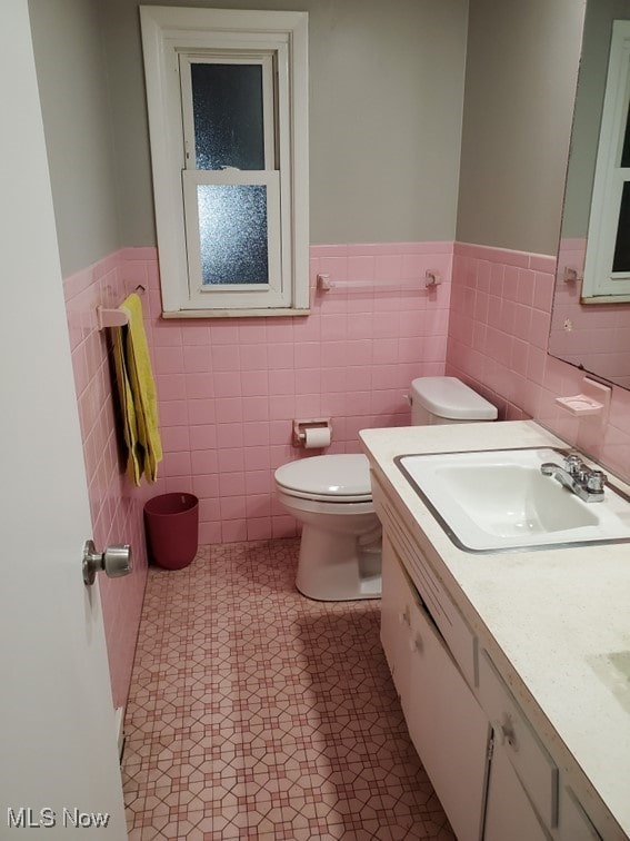 bathroom featuring vanity, toilet, and wainscoting