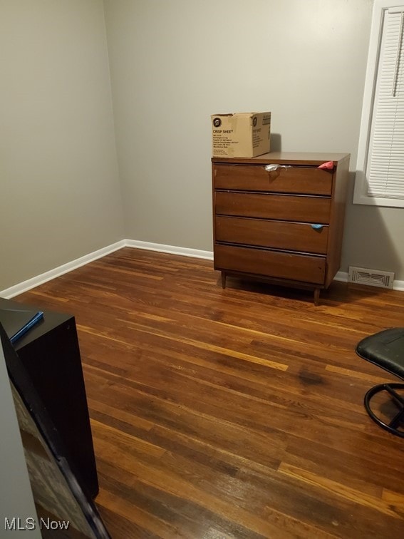 living area featuring baseboards, visible vents, and dark wood-type flooring