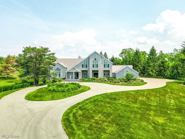 view of front of home with a front lawn and curved driveway