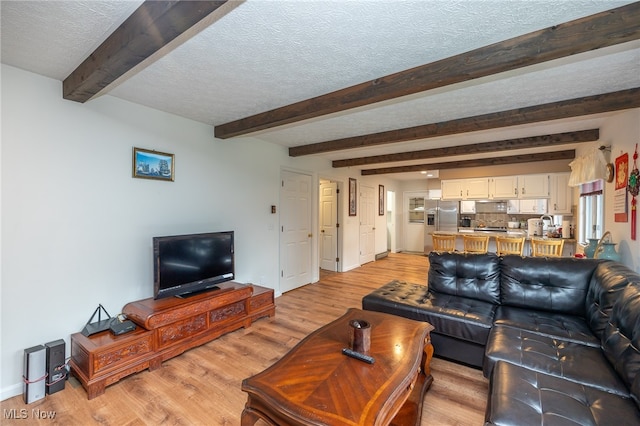 living room with beam ceiling, light hardwood / wood-style floors, and a textured ceiling