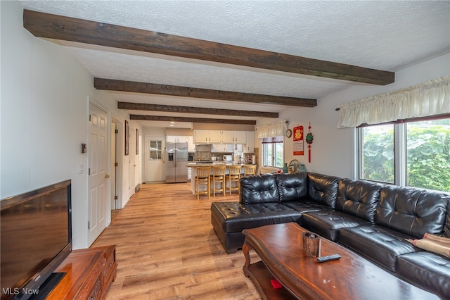 living room with beam ceiling, light hardwood / wood-style flooring, and a textured ceiling