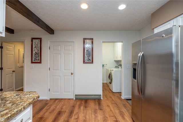 kitchen with washing machine and dryer, white cabinets, light hardwood / wood-style floors, and stainless steel refrigerator with ice dispenser