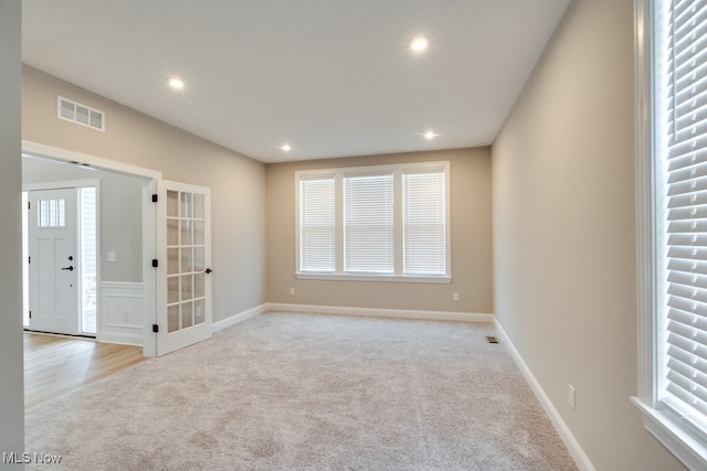 spare room with a healthy amount of sunlight and light carpet