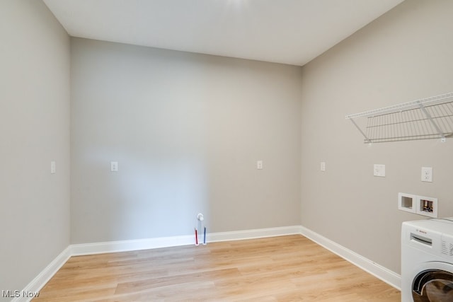 clothes washing area with light hardwood / wood-style floors and washer / dryer