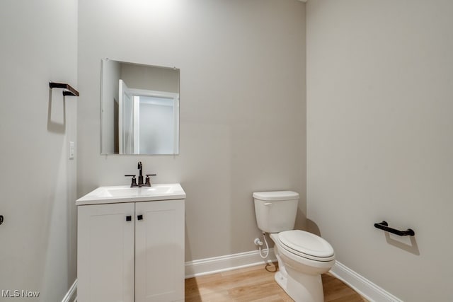 bathroom featuring toilet, vanity, and wood-type flooring