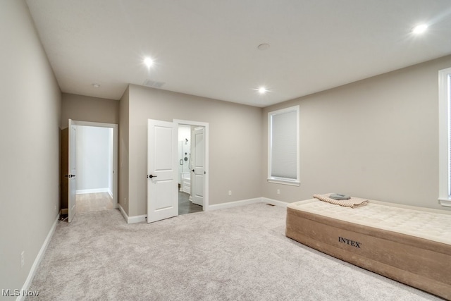 unfurnished bedroom featuring carpet floors and ensuite bathroom