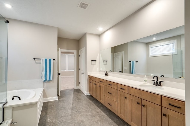 bathroom featuring tile patterned floors, dual vanity, and a tub to relax in