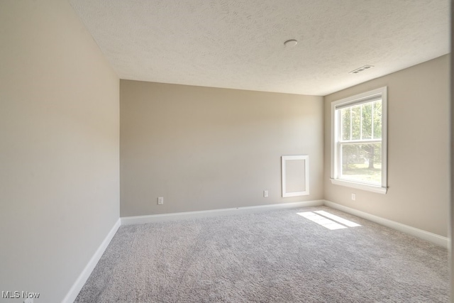 carpeted empty room featuring a textured ceiling