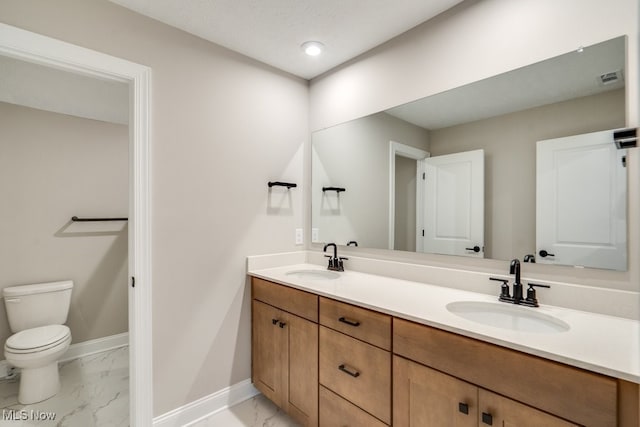 bathroom with toilet, double vanity, and tile patterned flooring