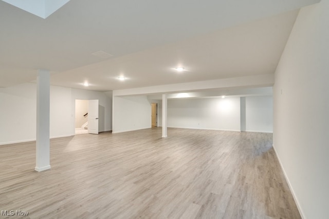 basement with light hardwood / wood-style flooring