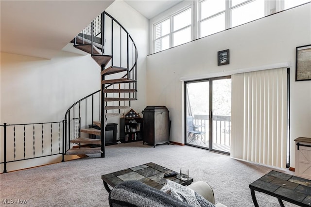 living room featuring a high ceiling, carpet floors, and a wealth of natural light