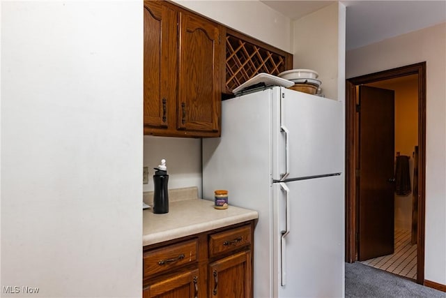 kitchen featuring white refrigerator and light colored carpet