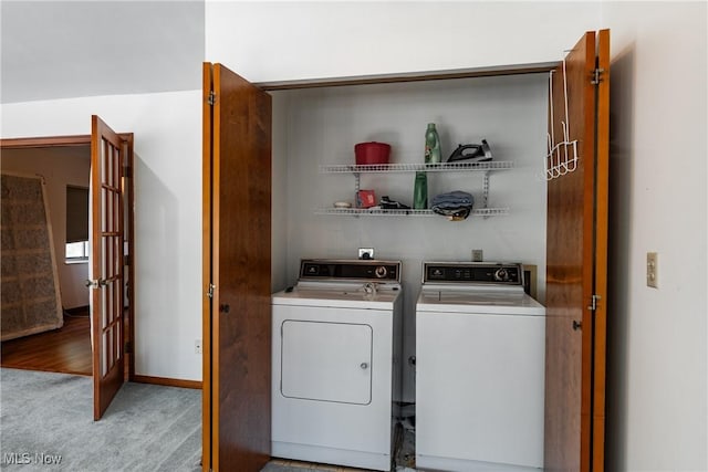 laundry room with separate washer and dryer and light colored carpet