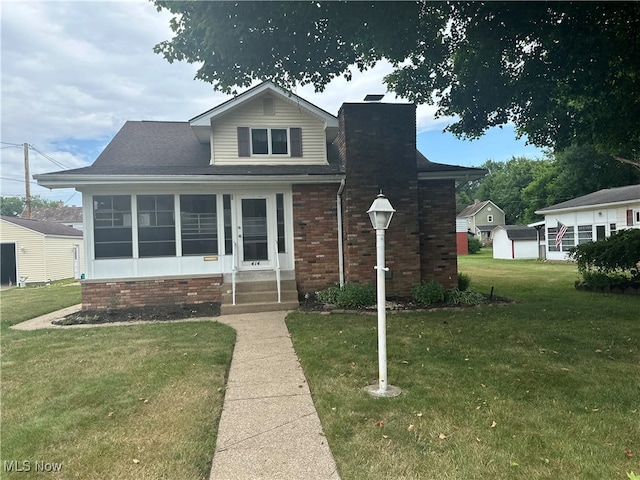 bungalow-style house with a front lawn, an outdoor structure, and a garage