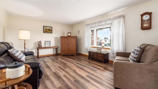 living area with baseboards and wood finished floors